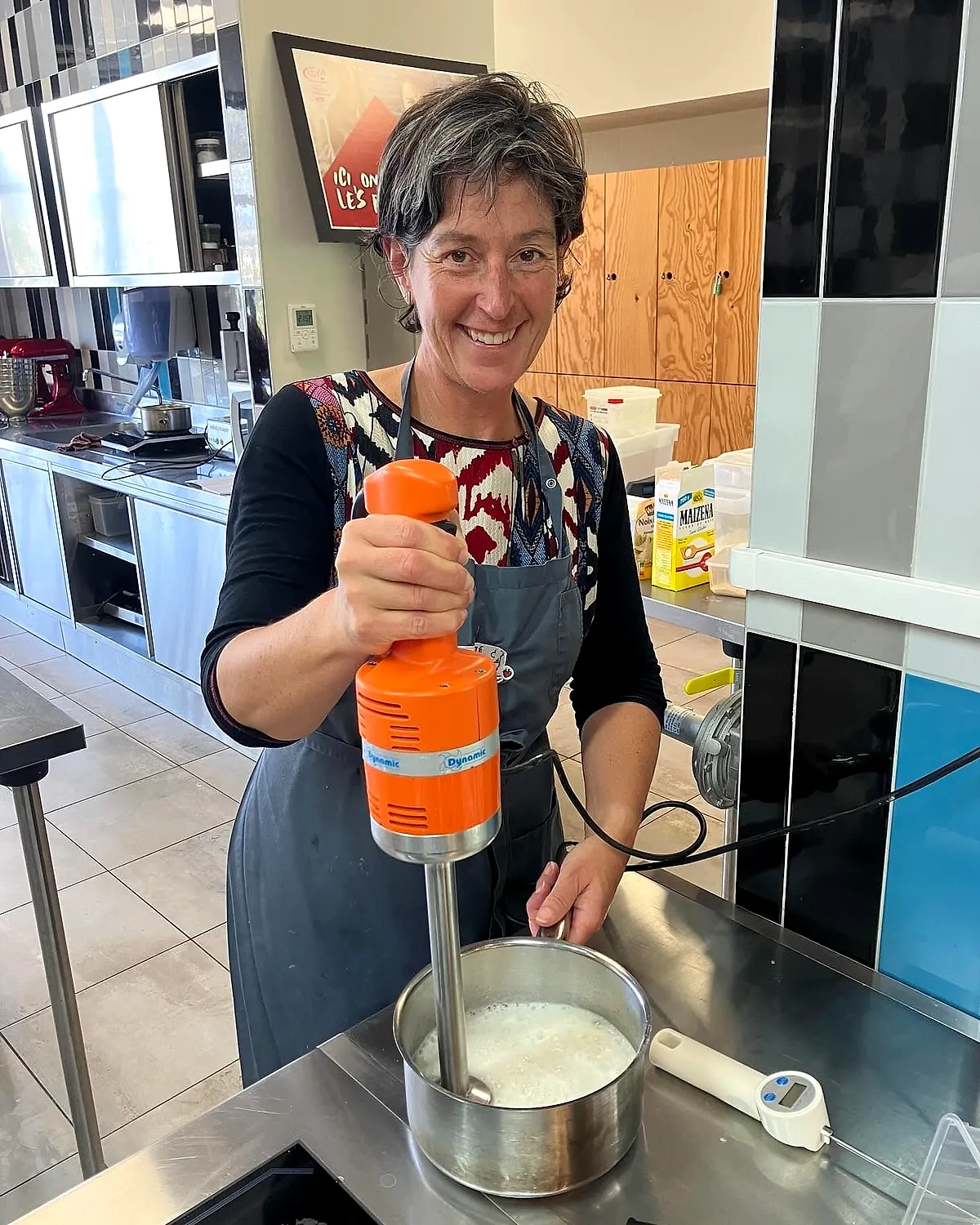 Anne en cuisine, un mixeur orange à la main