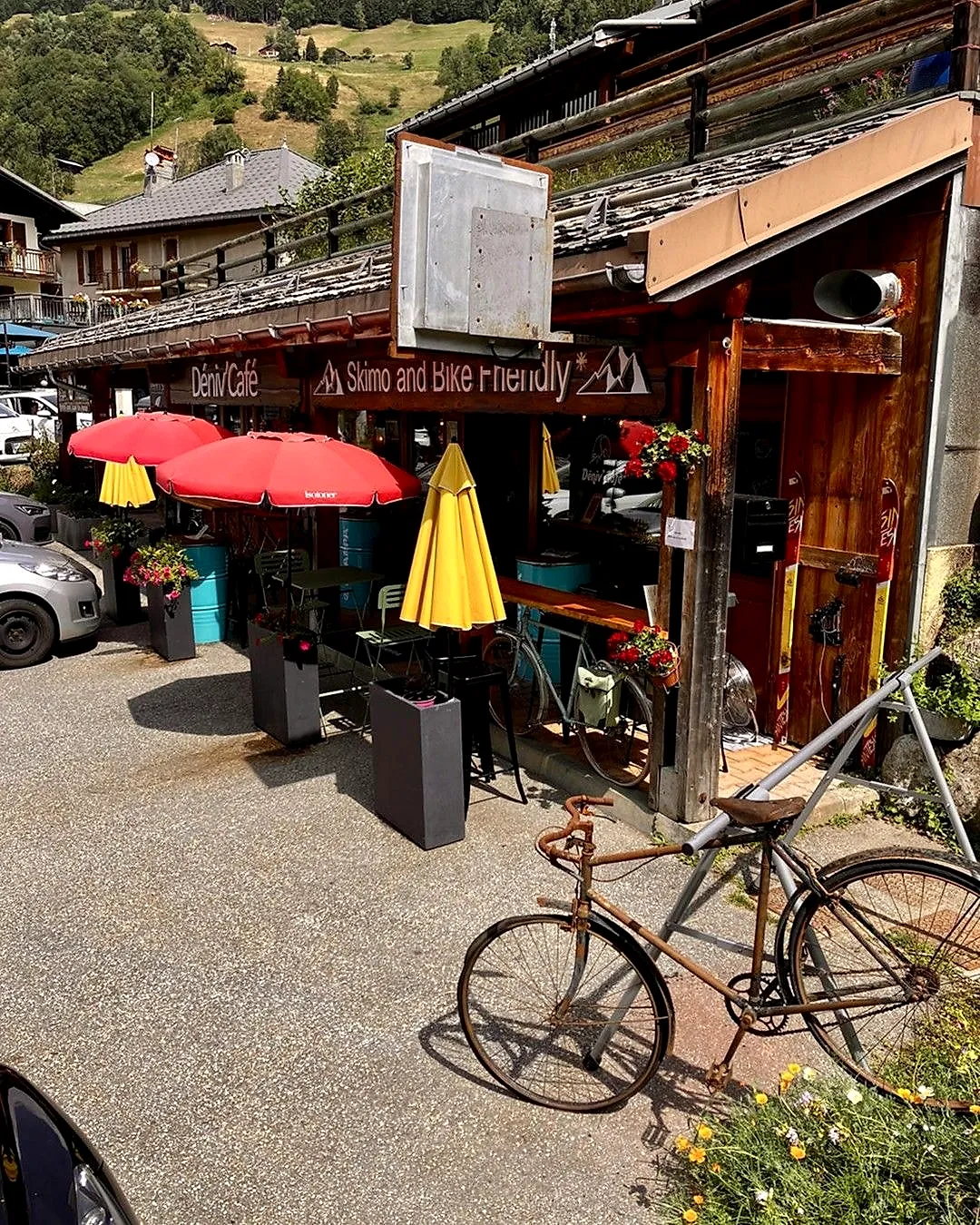 La terrasse aux parasols rouges et jaunes, un vieux vélo devant
