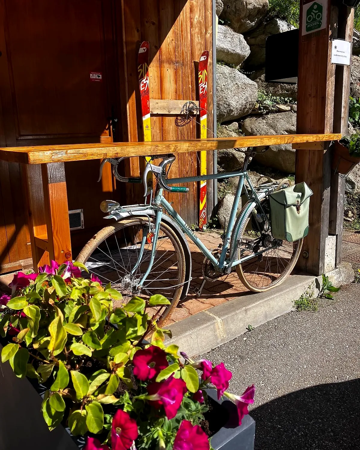 Un vélo garé contre le comptoir extérieur fleuri